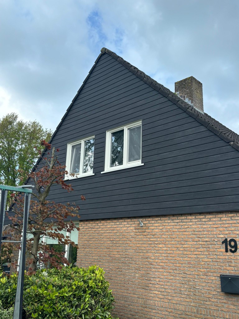 Gevel met witte kozijnen en donkere gevelbekleding